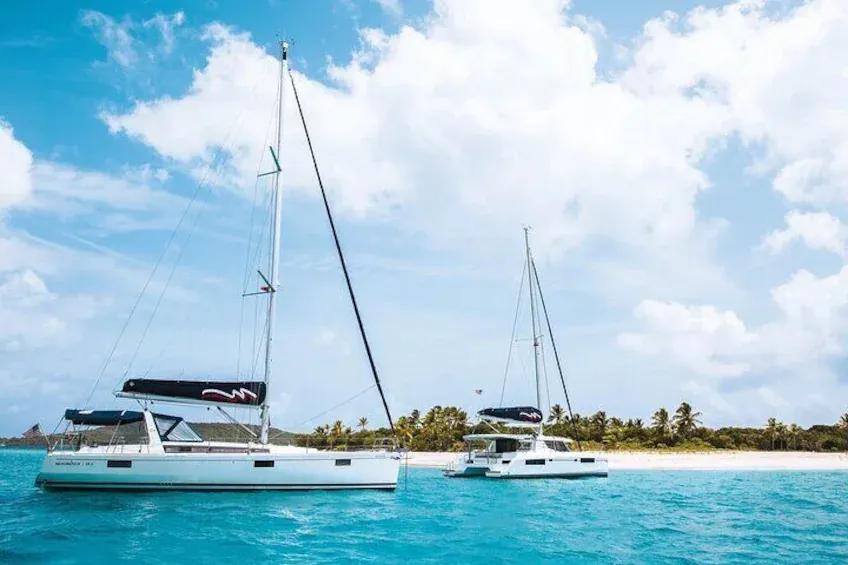 Two catamarans anchored in a turquoise lagoon
