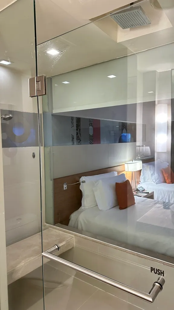 Glass-walled rain shower looking into the bedroom at Centara Grand Ladprao